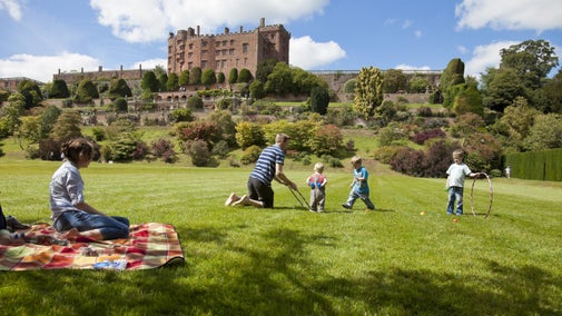 Family playing on the lawn at Powis Castle Garden in Powys, Wales